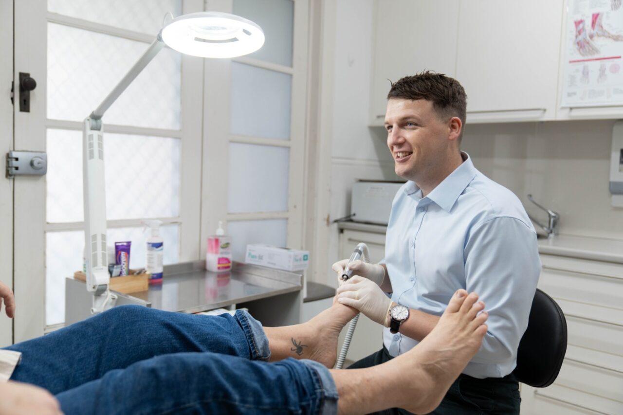 Podiatrist examining patient’s foot in clinic