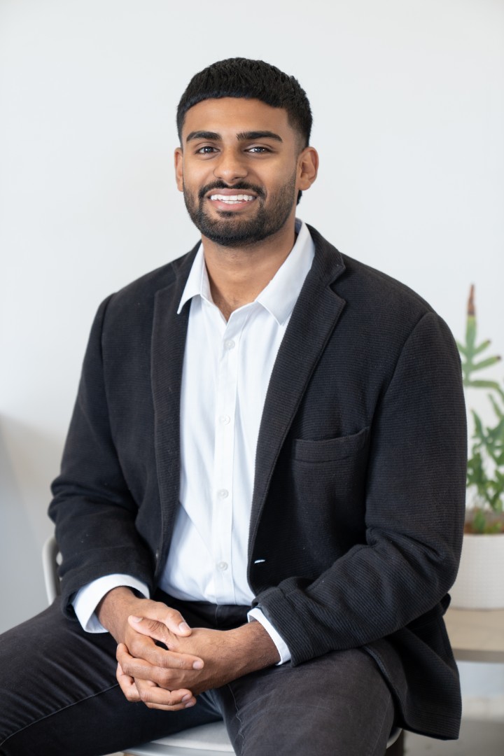Smiling man in blazer seated indoors