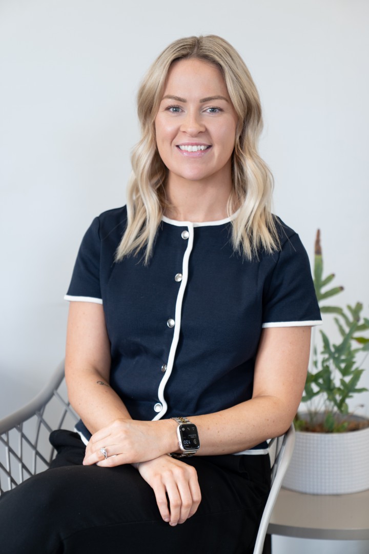 Smiling woman seated indoors in professional attire