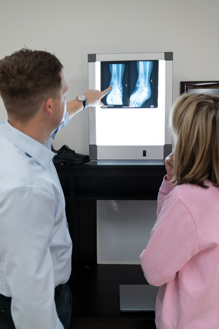 Doctor explaining ankle X-ray to patient